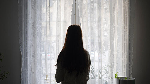 A woman looking out a window.