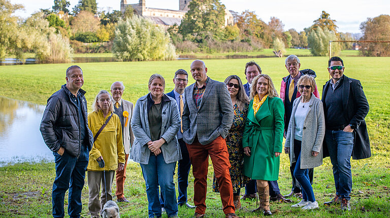 Tewkesbury Liberal Democrats stand in front of Tewkesbury Abbey