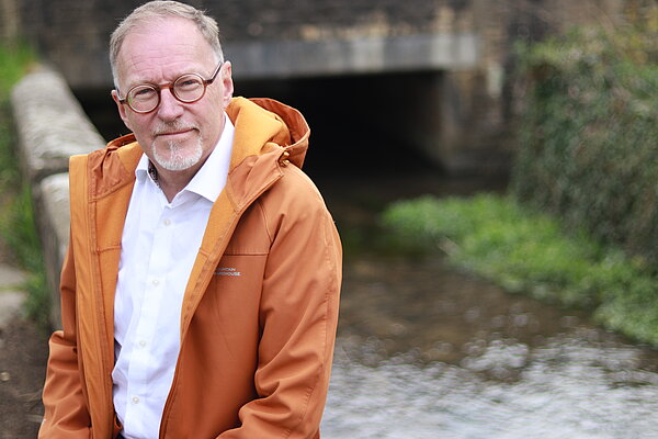 Paul Hodgkinson sat beside a polluted river.